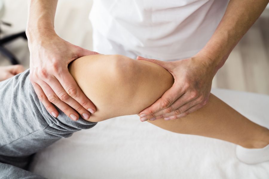 A physical therapist guides a patient through knee rehabilitation exercises to improve mobility and strength post-surgery